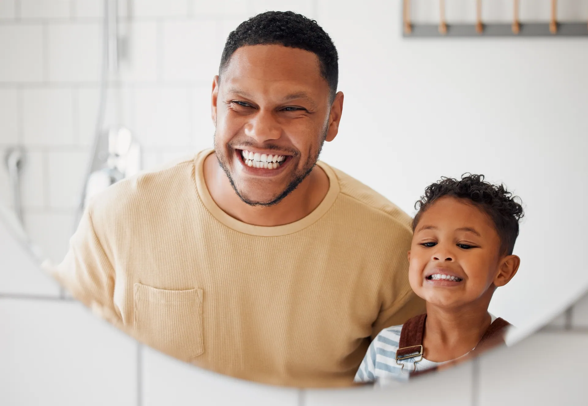 Father and son smiling together during a preventative dental exam